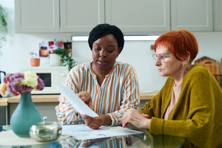 Volunteer helping senior woman with bills