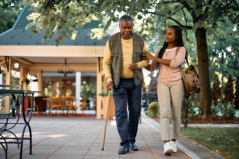 Younger woman and older man walking together outside