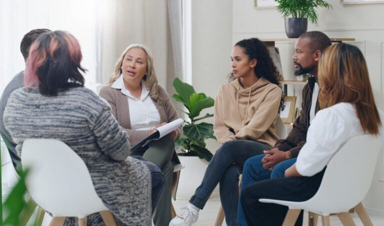 People sitting in a circle at a group therapy session