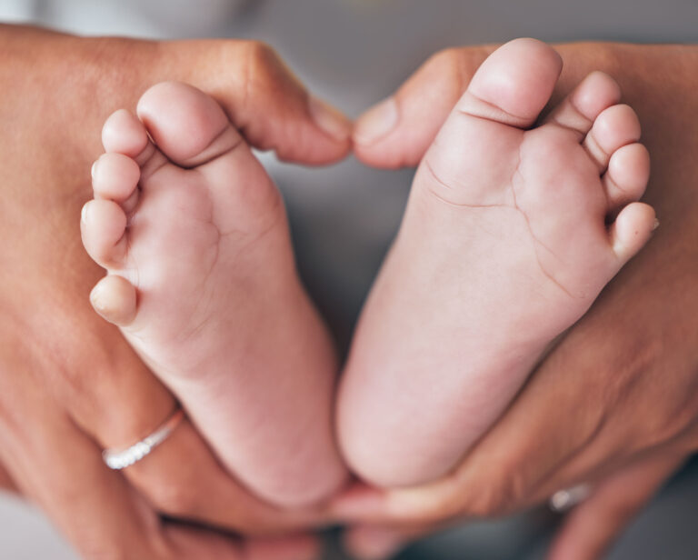 Closeup of hands holding a pair of baby feet