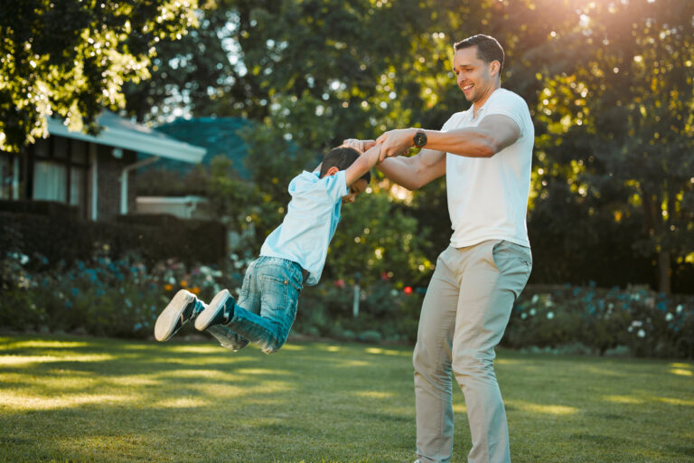 Father playing with his child around in a garden