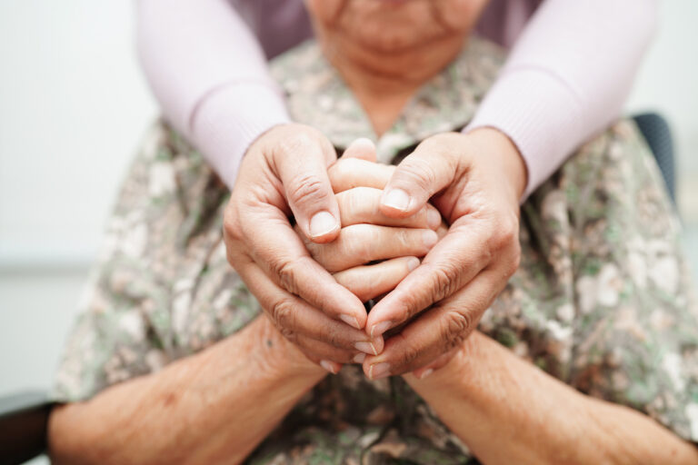 Caregiver holding another person's hands