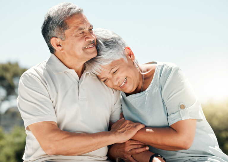 Happy senior couple hugging outside