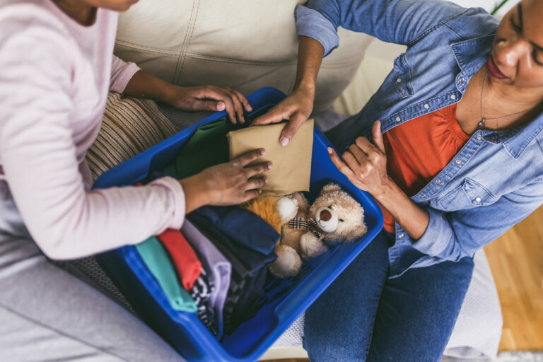 Top view of a mother and child adding items to a box